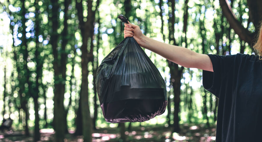 Close-up, a bag of garbage on a blurred background of the forest, the concept of ecology and love for nature.